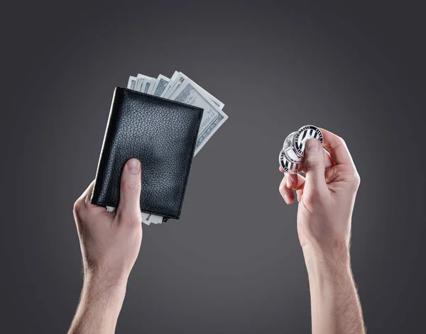 手与硬币和一个皮革钱包与 litecoin 硬币和美元钞票反对灰色背景。数字监控、支票和货币交换 cryptocurrency 概念 — 图库照片