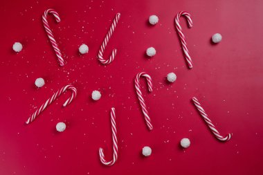 Kırmızı arka planda hindistan cevizi şekerleri ve beyaz şeker topları. Noel kartpostalı. Mutlu yıllar..