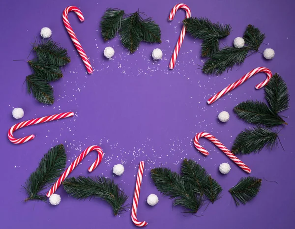 Doces com bolas brancas de coco estão em um círculo em um fundo roxo e ramos abeto. Cartão postal de Natal. Feliz Ano Novo conceito — Fotografia de Stock