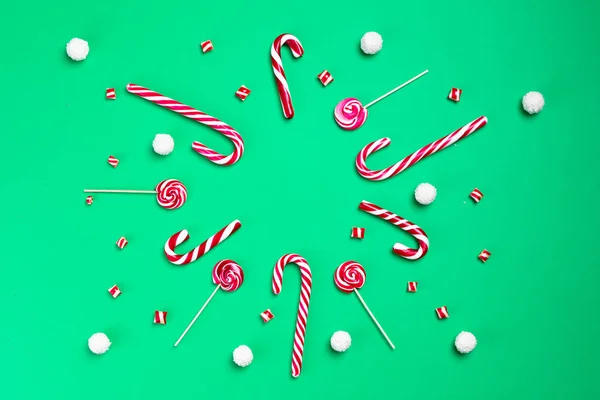 Candy Canes και γλειφιτζούρια με κλαδιά έλατο σε πράσινο φόντο. Καρύδες καρύδας. Χριστουγεννιάτικη κάρτα. Καλή Χρονιά. — Φωτογραφία Αρχείου