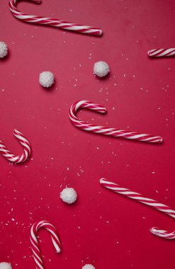 Kırmızı arka planda hindistan cevizi şekerleri ve beyaz şeker topları. Noel kartpostalı. Mutlu yıllar..