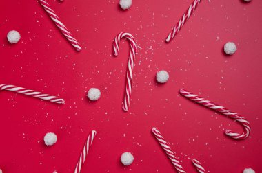 Kırmızı arka planda hindistan cevizi şekerleri ve beyaz şeker topları. Noel kartpostalı. Mutlu yıllar..