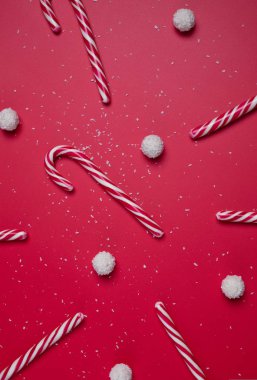 Kırmızı arka planda hindistan cevizi şekerleri ve beyaz şeker topları. Noel kartpostalı. Mutlu yıllar..