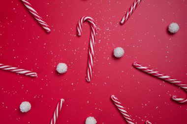 Kırmızı arka planda hindistan cevizi şekerleri ve beyaz şeker topları. Noel kartpostalı. Mutlu yıllar..