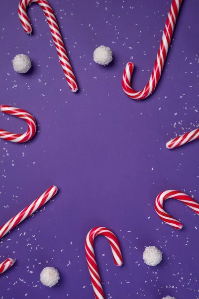 Cukierki z białymi kulkami kokosowymi są w kole na fioletowym tle i gałązki jodły. Świąteczna pocztówka. Szczęśliwego Nowego Roku — Zdjęcie stockowe