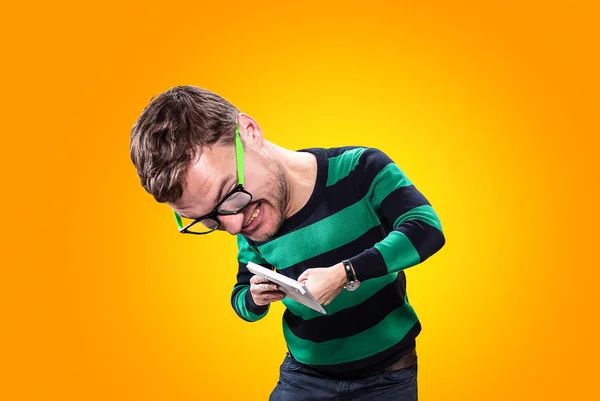 Карикатура на молодого человека с большой головой и крошечным телом. Злой молодой человек держит в руках клавиатуру и пытается сломать её на жёлтом фоне. Студия фото . — стоковое фото