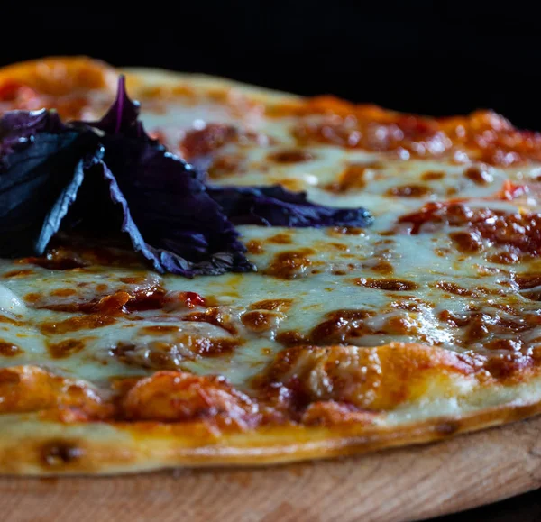 Fermer Italie pizza chaude au fromage, tomates et basilic violet isolé sur fond noir — Photo