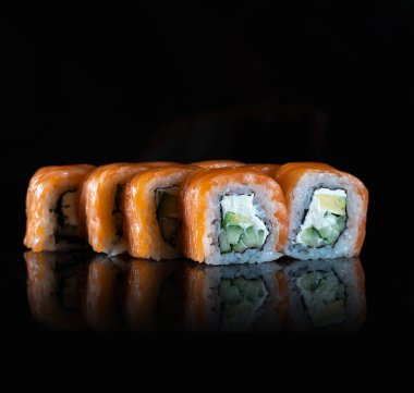 Japanese Sushi isolated on black background. Reflection in a mirror surface. Close up. Studio photo.