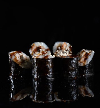 Japanese Sushi isolated on black background. Reflection in a mirror surface. Close up. Studio photo.