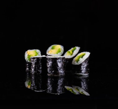 Japanese Sushi isolated on black background. Reflection in a mirror surface. Close up. Studio photo.