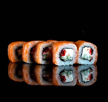Japanese Sushi isolated on black background. Reflection in a mirror surface. Close up. Studio photo.