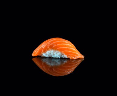 Japanese Sushi isolated on black background. Reflection in a mirror surface. Close up. Studio photo.