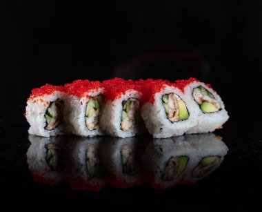 Japanese Sushi isolated on black background. Reflection in a mirror surface. Close up. Studio photo.