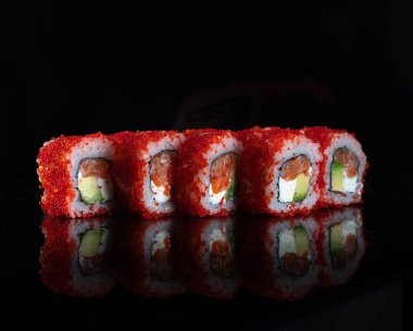 Japanese Sushi isolated on black background. Reflection in a mirror surface. Close up. Studio photo.