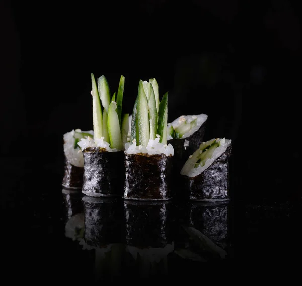 Sushi japonés aislado sobre fondo negro. Reflexión en una superficie de espejo. De cerca. Estudio foto . — Foto de Stock