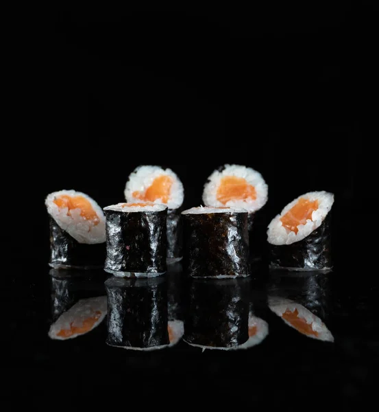 Sushi japonés aislado sobre fondo negro. Reflexión en una superficie de espejo. De cerca. Estudio foto . — Foto de Stock