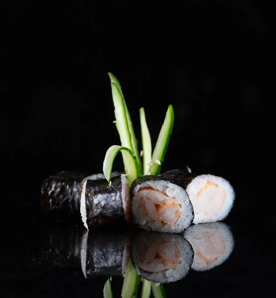 Japanese Sushi isolated on black background. Reflection in a mirror surface. Close up. Studio photo.