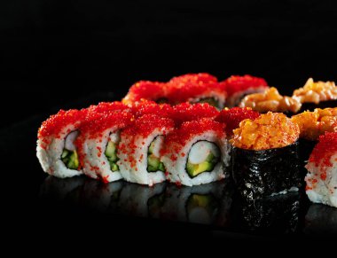 Japanese Sushi isolated on black background. Reflection in a mirror surface. Close up. Studio photo.