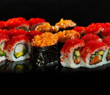 Japanese Sushi isolated on black background. Reflection in a mirror surface. Close up. Studio photo.