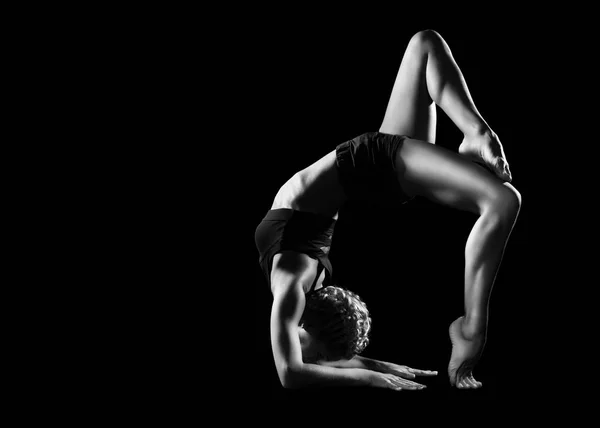 Black and white picture of a woman practicing bridge yoga pose i