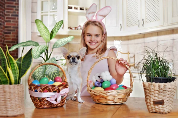 Happy blonde girl with her chihuahua at the easter kitchen