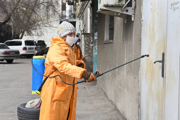 Almaty / Kazakistan-03.26.2020: şehirdeki konut binalarının girişleriyle özel takım elbiseli kişiler ilgileniyor