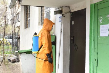 Almaty / Kazakistan - 03.26.2020: özel takım elbiseli bir adam şehirdeki evlerin girişleriyle ilgileniyor