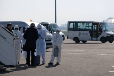 Almaty / Kazakistan - 03.27.2020: güvenlik ve sağlık personeli karantina sırasında yolcularla buluştu