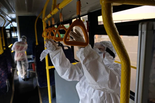 Almaty / Kazakistan - 03.18.2020: özel takım elbiseli bir kadın tırabzanları yıkar