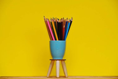 Bir seramik içinde renkli kalemler seti yukarı ve bir standa