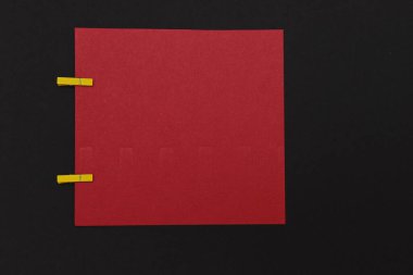 İki mandallı büyük bir kare kırmızı kağıt.