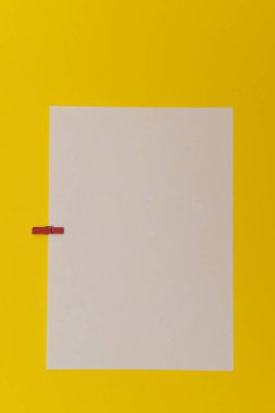 Parlak arkaplanda mandalları olan renkli kağıtlar.