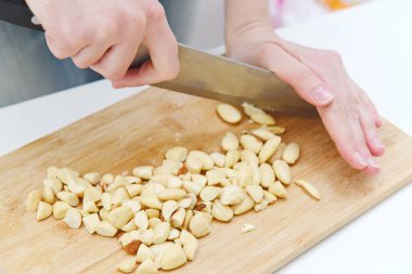 Soyulmuş fındıklar tahtada bıçakla doğranmış.
