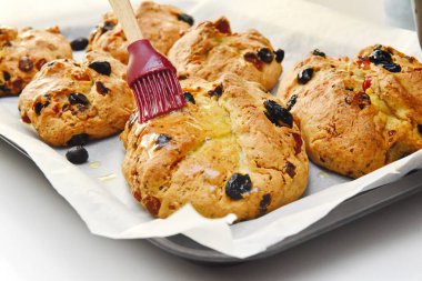 Taze pişmiş çörekler sosla kaplıdır.