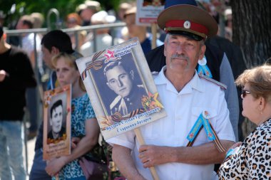 Almaty / Kazakistan - 05.09.2019: Ölümsüz Alay 'ın Mart ayı. İnsanlar büyük vatanseverlik savaşında ölenlerin akrabalarının fotoğraflarıyla gidiyorlar.