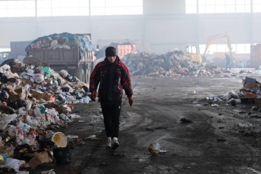 Almaty / Kazakistan - 11.26.2018: Geri dönüşüm tesisi. Özel takım elbiseli işçiler ev atıklarını ayırıyor