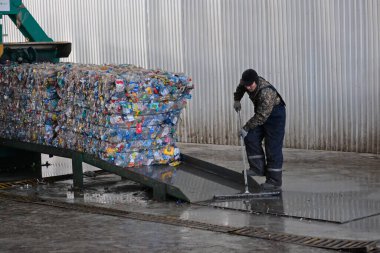 Almaty / Kazakistan - 11.26.2018: Geri dönüşüm tesisi. Özel takım elbiseli işçiler ev atıklarını ayırıyor