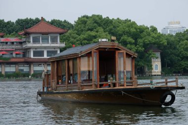 Hangzhou / Çin - 05.16.2019: Su turistleri. İnsanlar Çin tarzında eski bir teknede yelken açıyorlar..