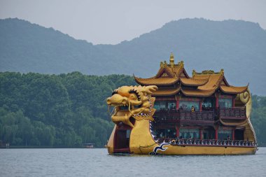 Hangzhou / Çin - 05.16.2019: Su turistleri. İnsanlar Çin tarzında eski bir teknede yelken açıyorlar..
