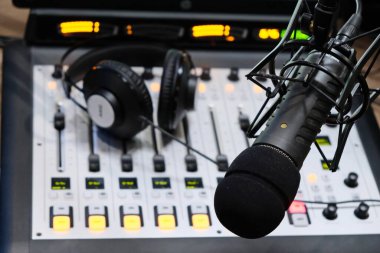 Editoryal Materyal / Almaty / Kazakistan - 11.20.2018: Mikser ve kulaklıkların arka planına sahip radyo stüdyosunda kayıt için mikrofon