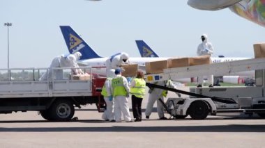 Almaty / Kazakistan - 04.23.2020: Havaalanında bir Pazar Havayolları uçağından tıbbi malzemeyle insani yardım kargosunun boşaltılması