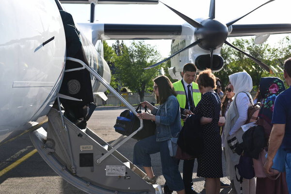 Алматы / Казахстан - 05.08.2019: Пассажиры садятся на самолет Qazaq Air в аэропорту
