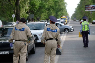 Almaty / Kazakistan - 04.28.2020: Coronavirus karantinası sırasında araç ve vatandaşların kontrol noktası