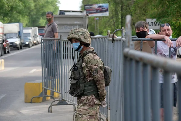 Almaty / Kazakistan - 04.28.2020: Asker karantina sırasında kontrol noktasındaki bölgeyi kontrol ediyor