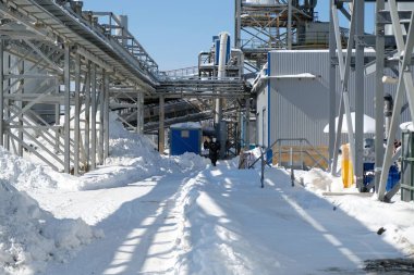 Magadan / Rusya - 03.20.2019: Tulumlu işçiler metalürji fabrikasının bölgesinden geçiyor