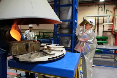 Magadan / Rusya - 03.20.2019: Tulumlu bir işçi metalin erimesini izliyor