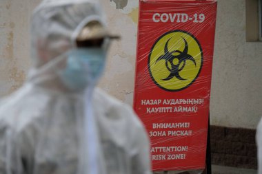 Almaty / Kazakistan - 05.02.2020: COVID-19 kelimeleriyle pankart ve risk bölgesi hakkında uyarı.