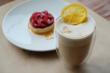 Kafenin müşterilerine servis etmeden önce el işi kağıdında kahve kokteyli ve çilek tatlısı.