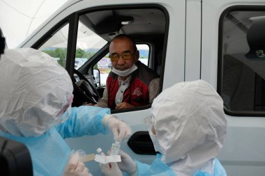 Almaty / Kazakistan - 05.15.2020: Mobil istasyondaki sağlık görevlileri koronavirüs testi yapıyorlar