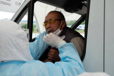 Almaty / Kazakistan - 05.15.2020: Mobil istasyondaki sağlık görevlileri koronavirüs testi yapıyorlar